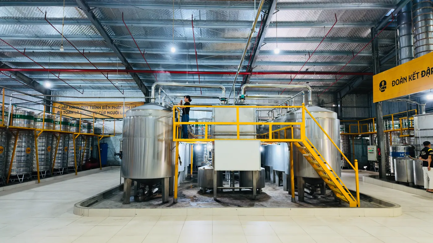 Khu chưng cất của nhà máy 9 Chum: dàn nồi cất inox và cầu thang thao tác trong xưởng